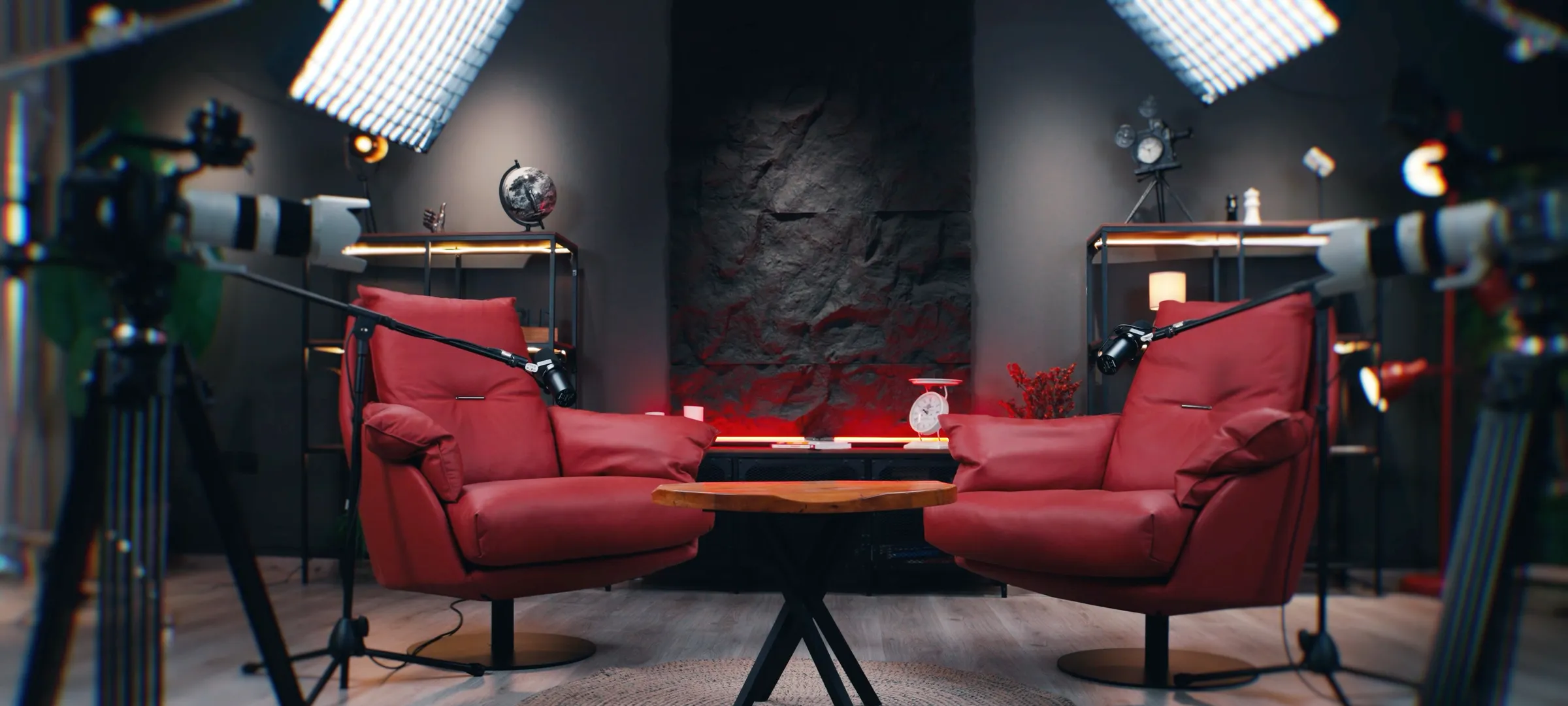 Plateau BLACK STONE prêt pour une interview : deux fauteuils face à face, caméras sur trépied et panneaux lumineux.