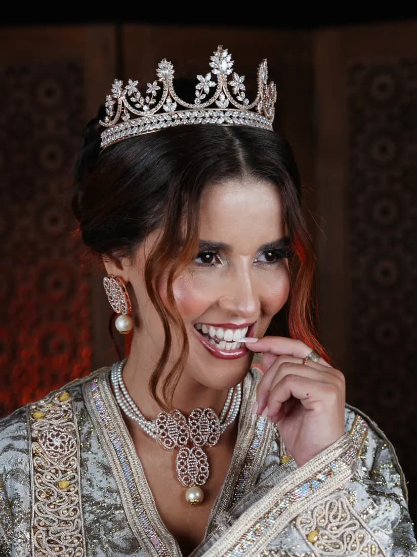 Portrait souriant avec couronne et caftan brodé.