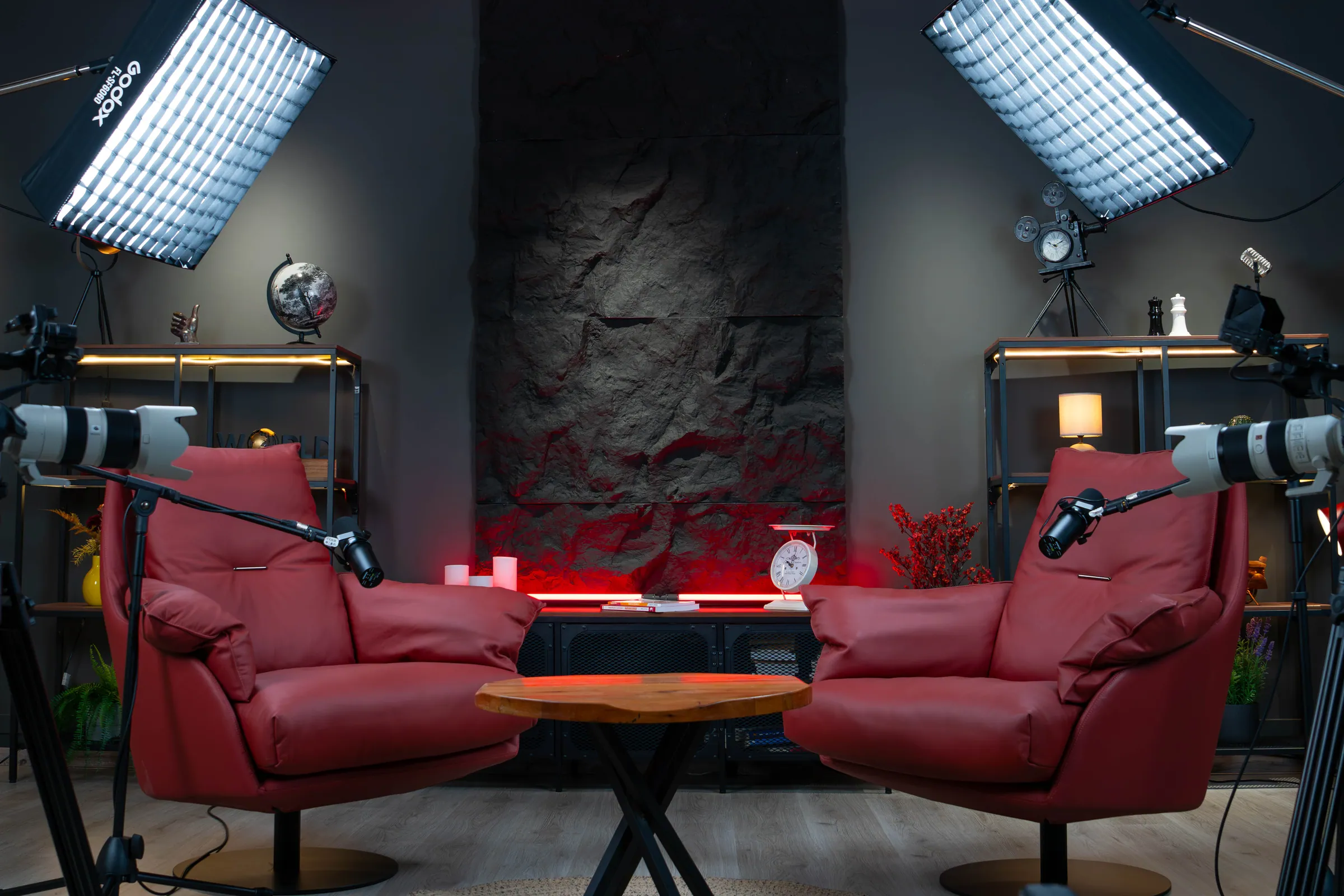Plateau BLACK STONE : un fauteuil rouge, une table basse et une étagère éclairée.